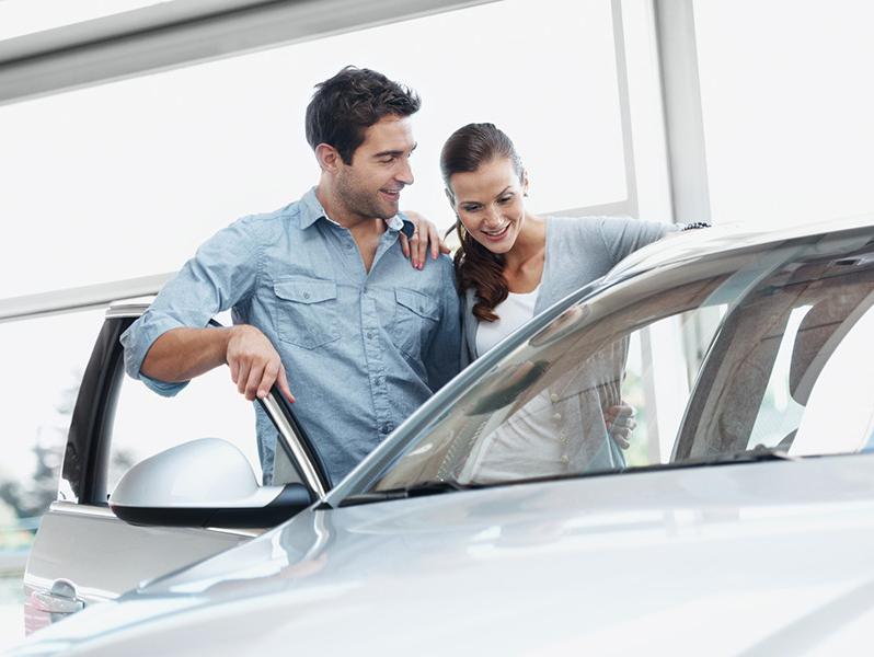Couple considering test drive at a dealership.