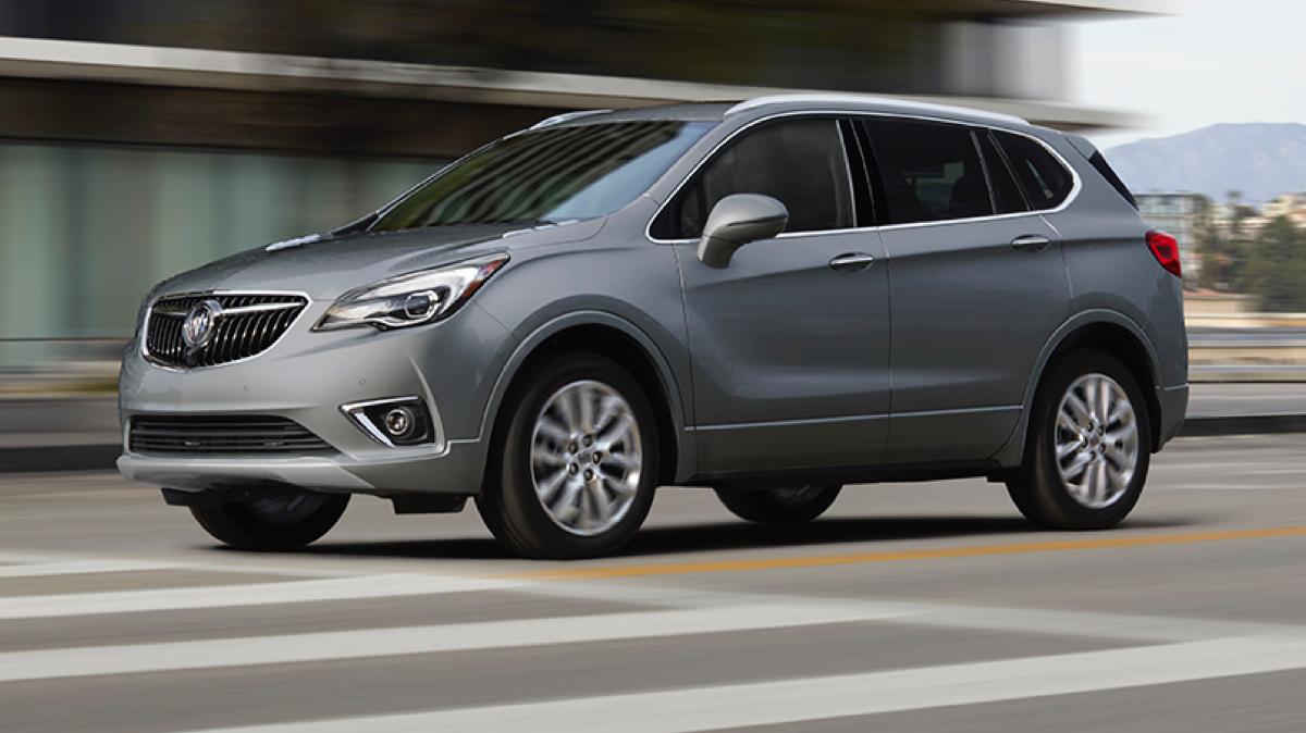 Sliver Buick SUV driving on a city street Sliver Buick SUV driving on a city street