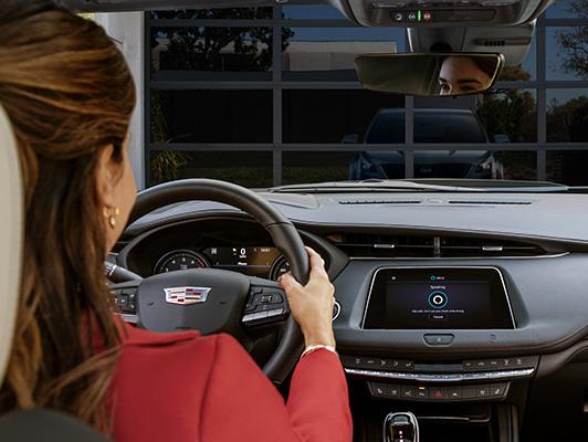 Woman in car in driveway with alexa on display screen