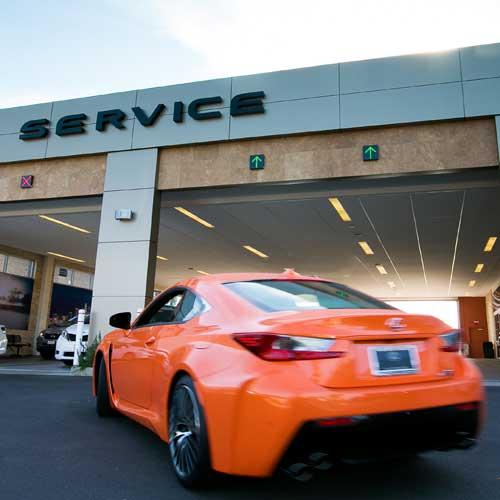 Orange Lexus vehicle pulling in to a service bay