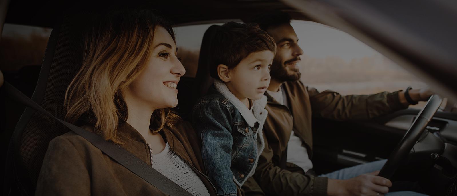 Happy young family sitting in the car.
