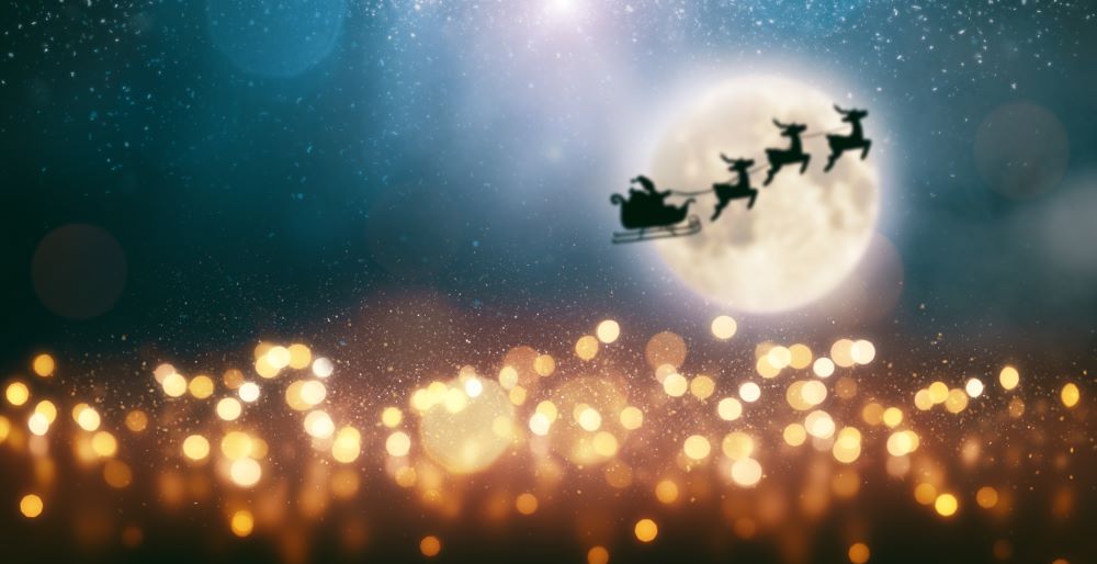 Santa and reindeer flying in front of moon