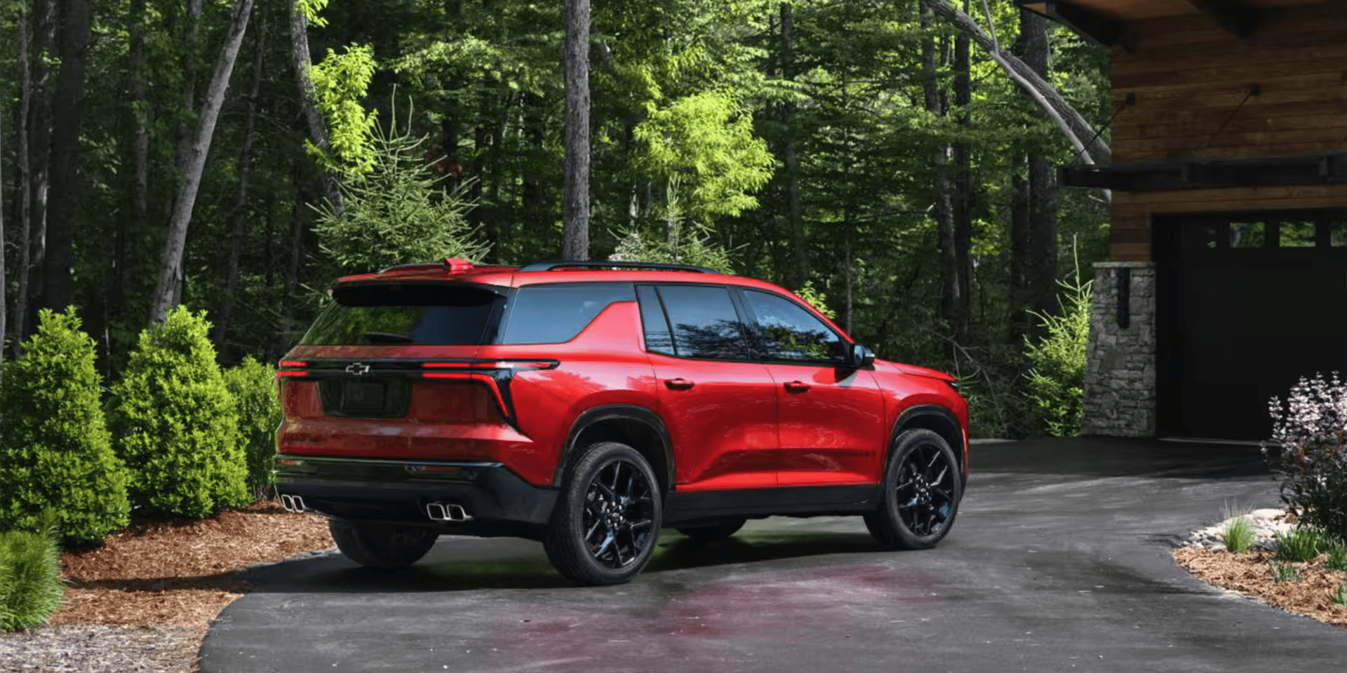 A red 2025 Chevrolet Traverse parked in a driveway