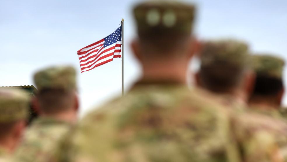 Military Personal Facing American Flag