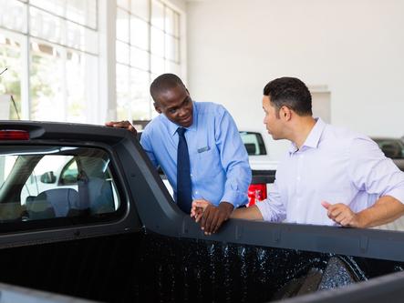 Man talking to car salesman about buying a used truck