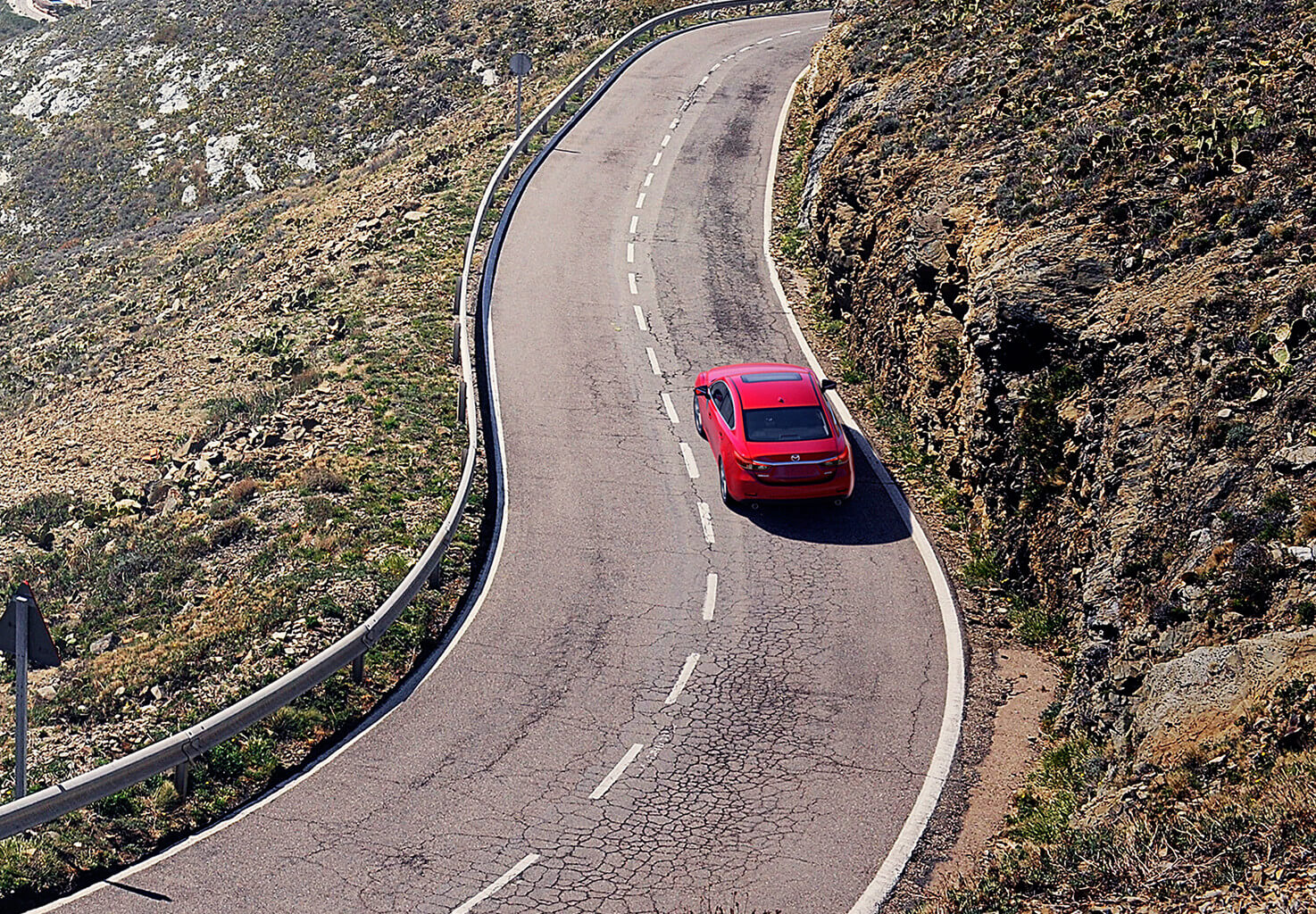 A red Mazda making it"s way up the road