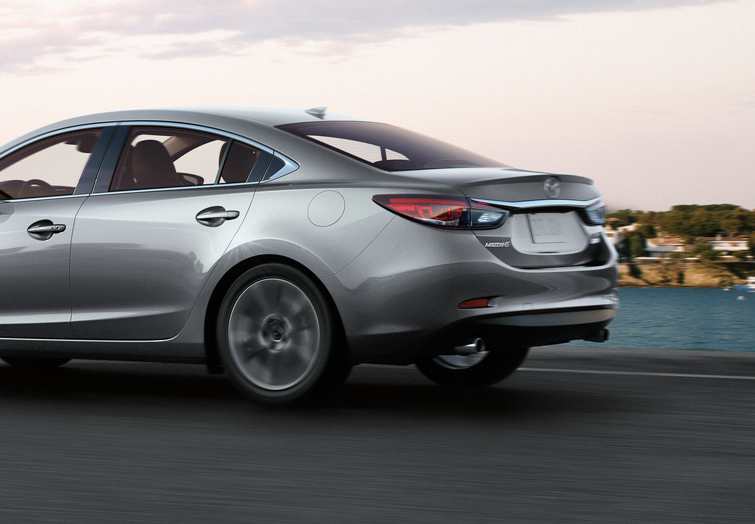Silver Mazda6 going fast down the road