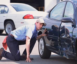 Technician checking car damage