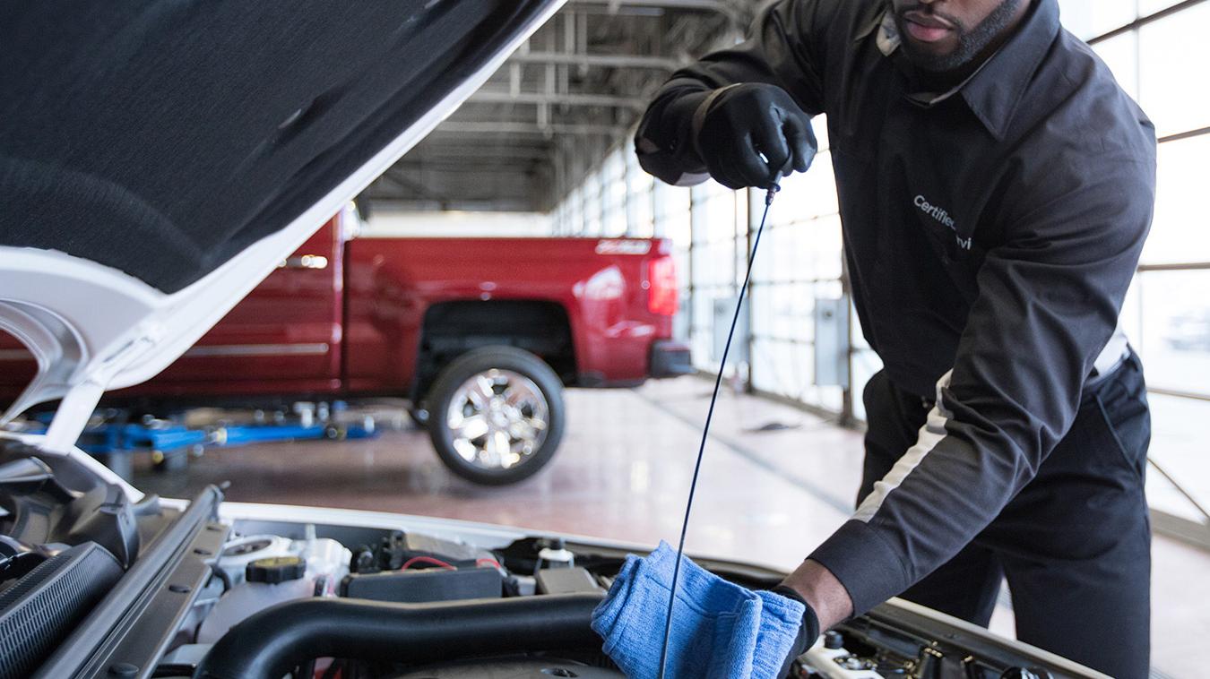 Service technician checking vehicle oil