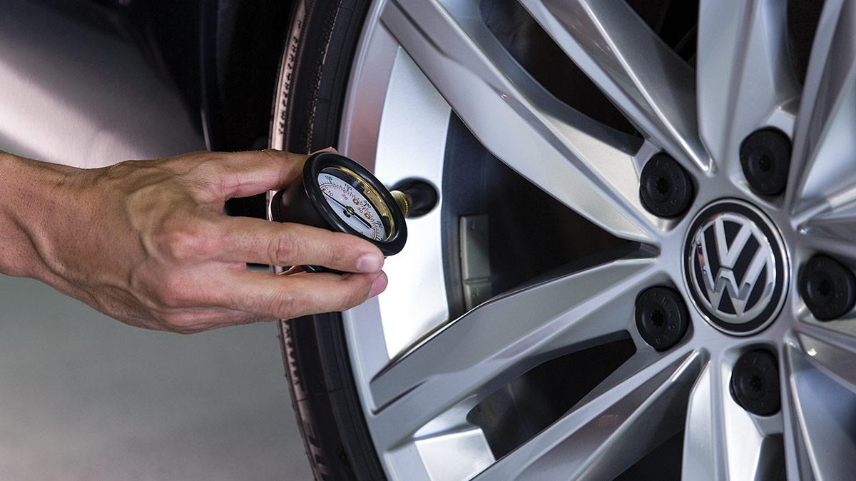 Volkswagen service technician checking tire gauge