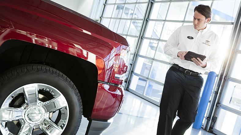 Service technician inspecting vehicle Service technician inspecting vehicle