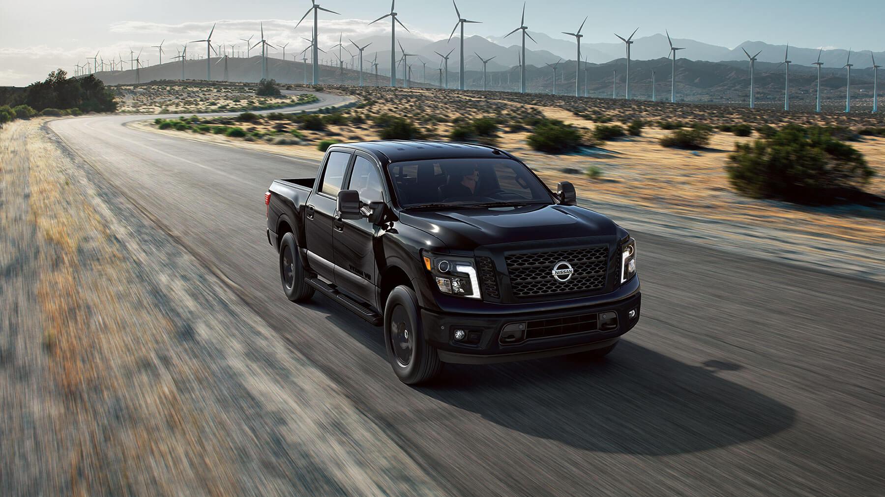 Nissan Truck Driving down flat road with windmills behind