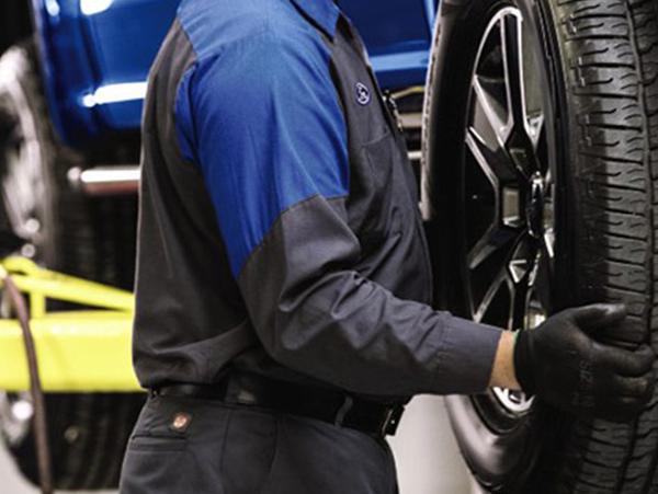 Ford Tire Tech putting tire on vehicle