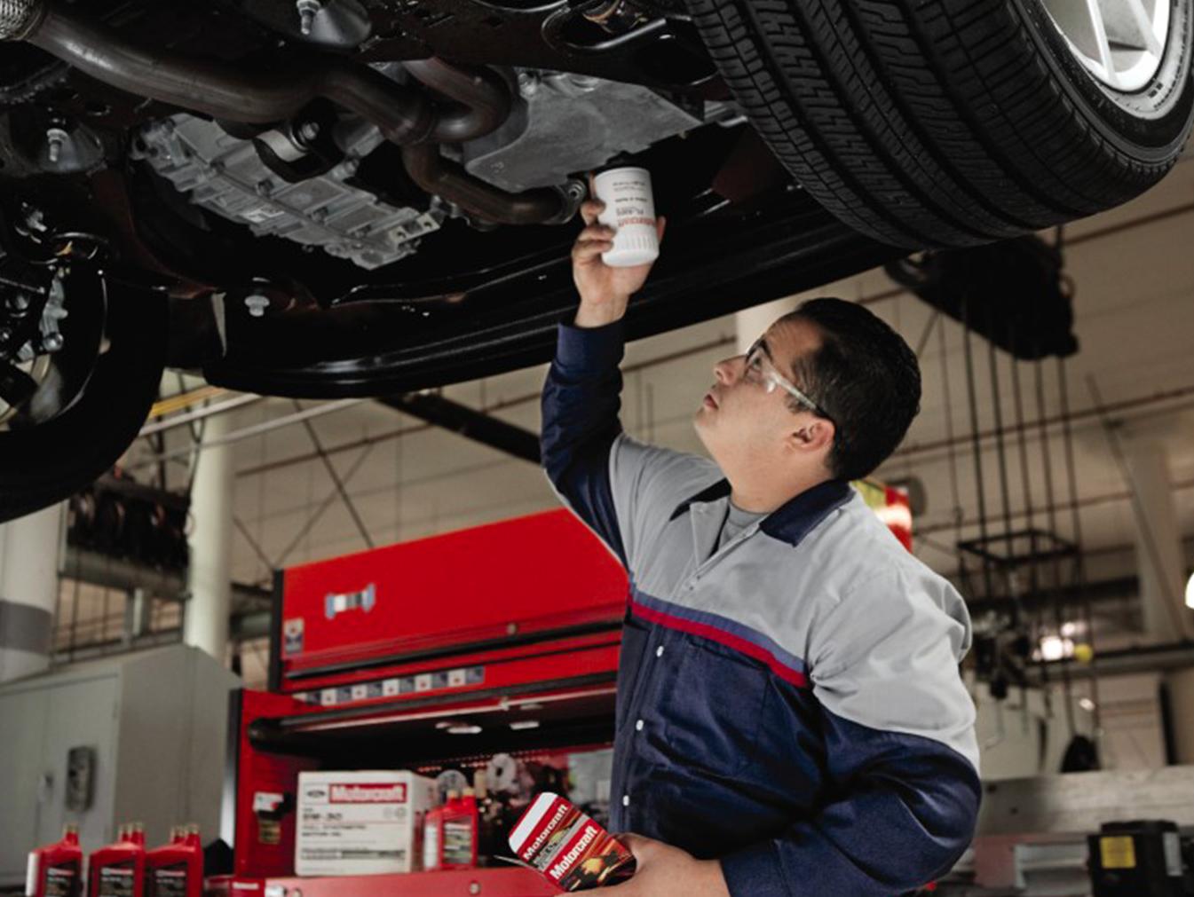 Service technician changing oil in vehicle
