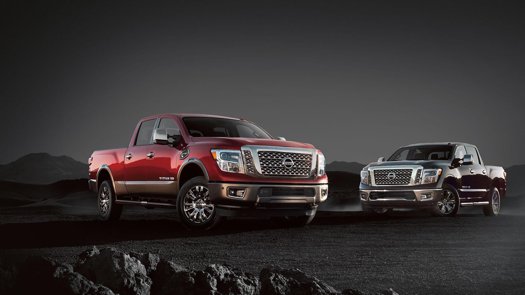 Nissan Trucks sitting in gravel with dark background