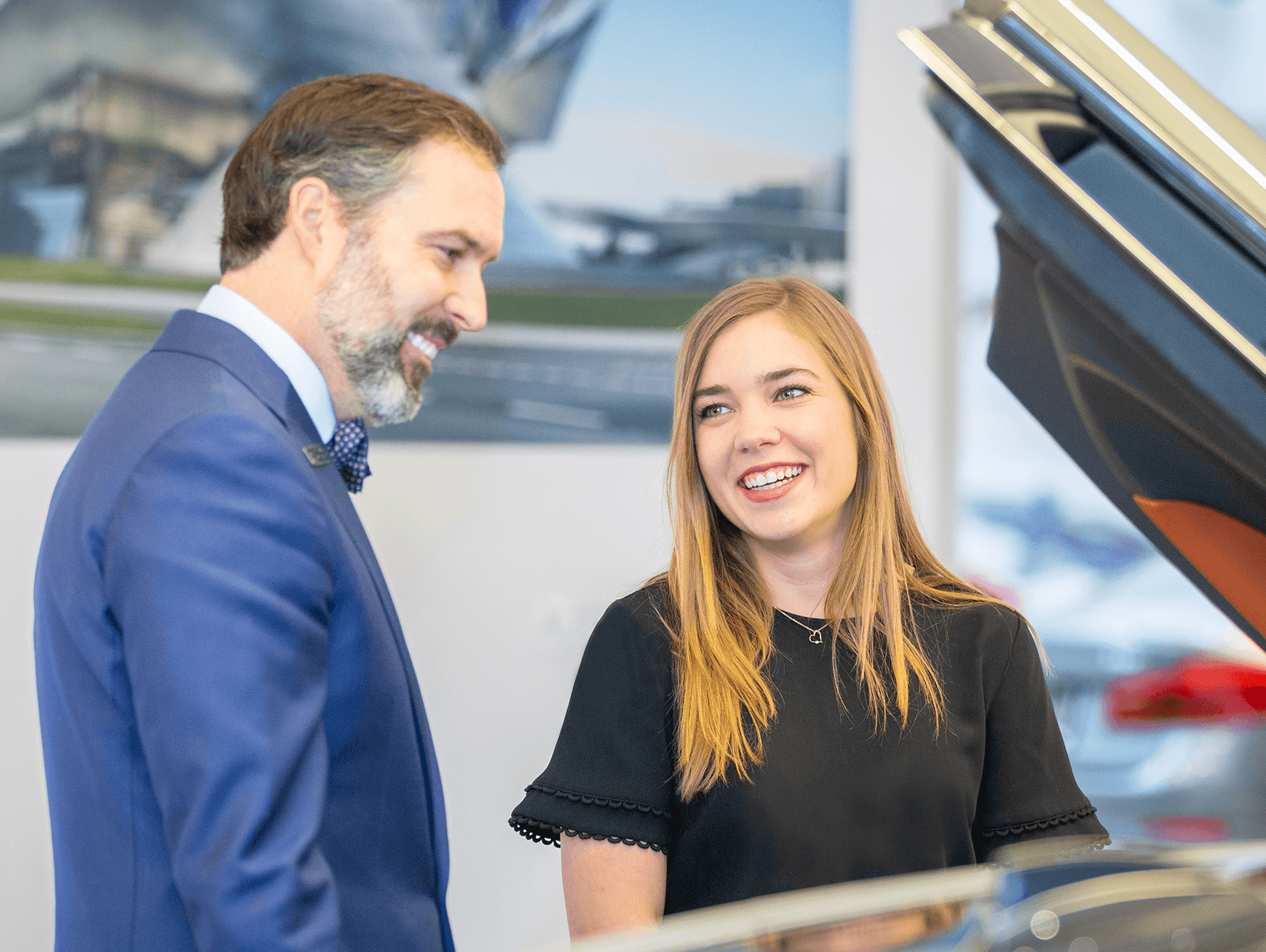 Woman and man smiling while looking at new vehicle