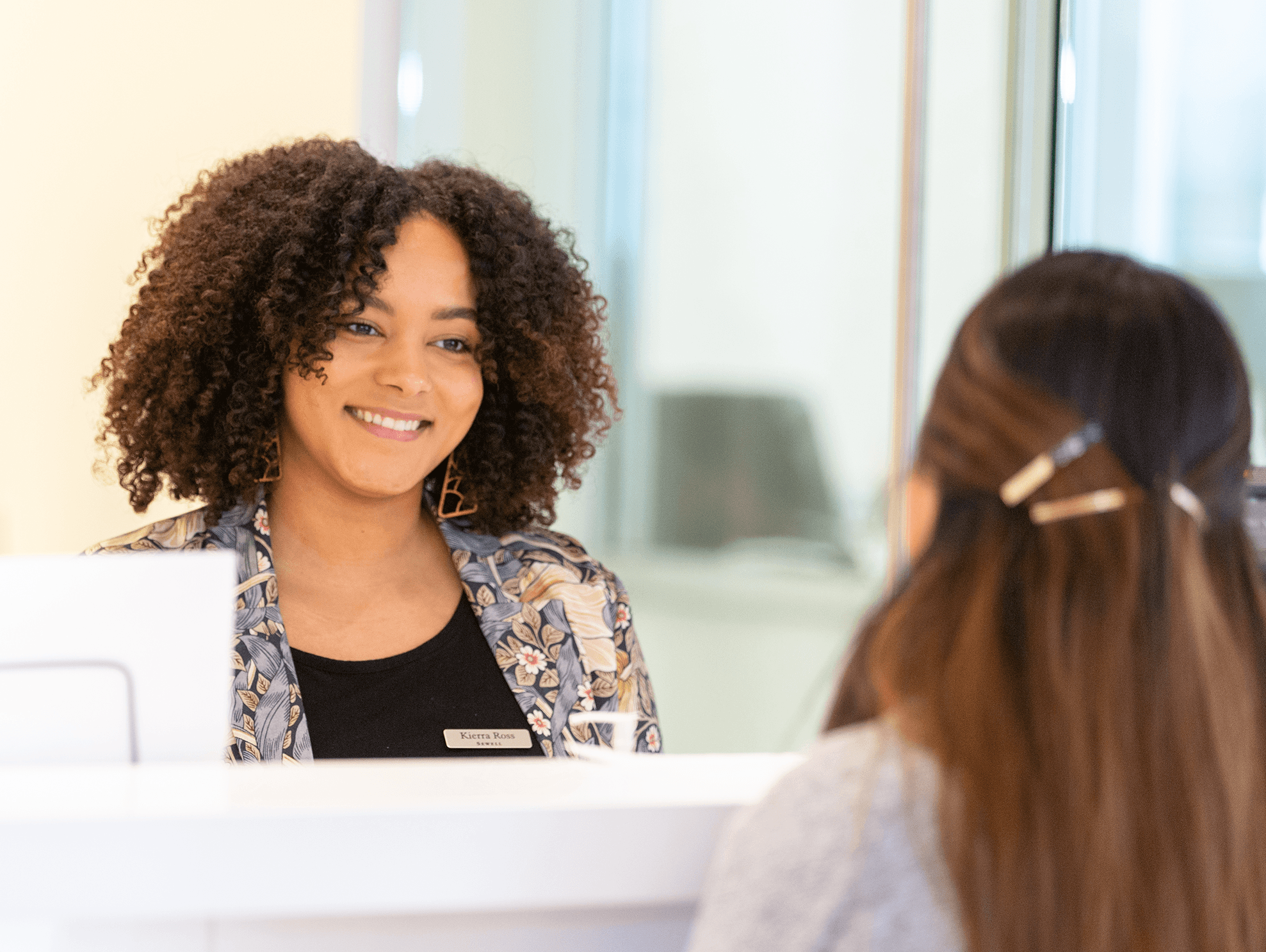 Dealership receptionist helping female customer