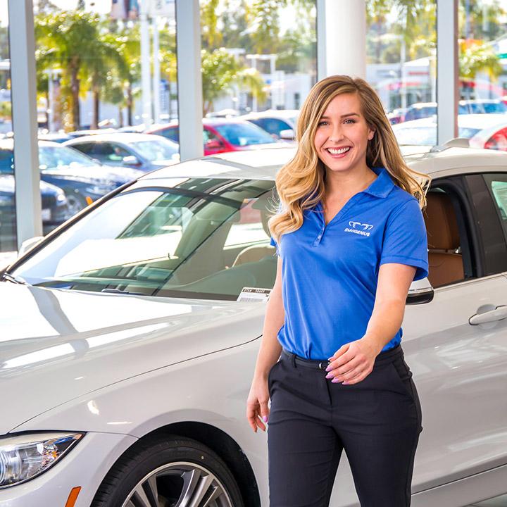 A young woman BMW associate walking through the showroom.