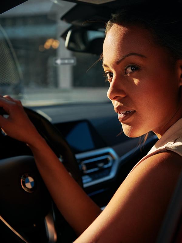 Close-up of a woman in a the driver's seat of a red BMW. Close-up of a woman in a the driver's seat of a red BMW.