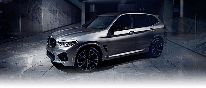 A silver BMW X3 M parked in a marble hallway.