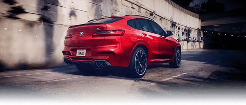 A red BMW X4 M driving into a tunnel.