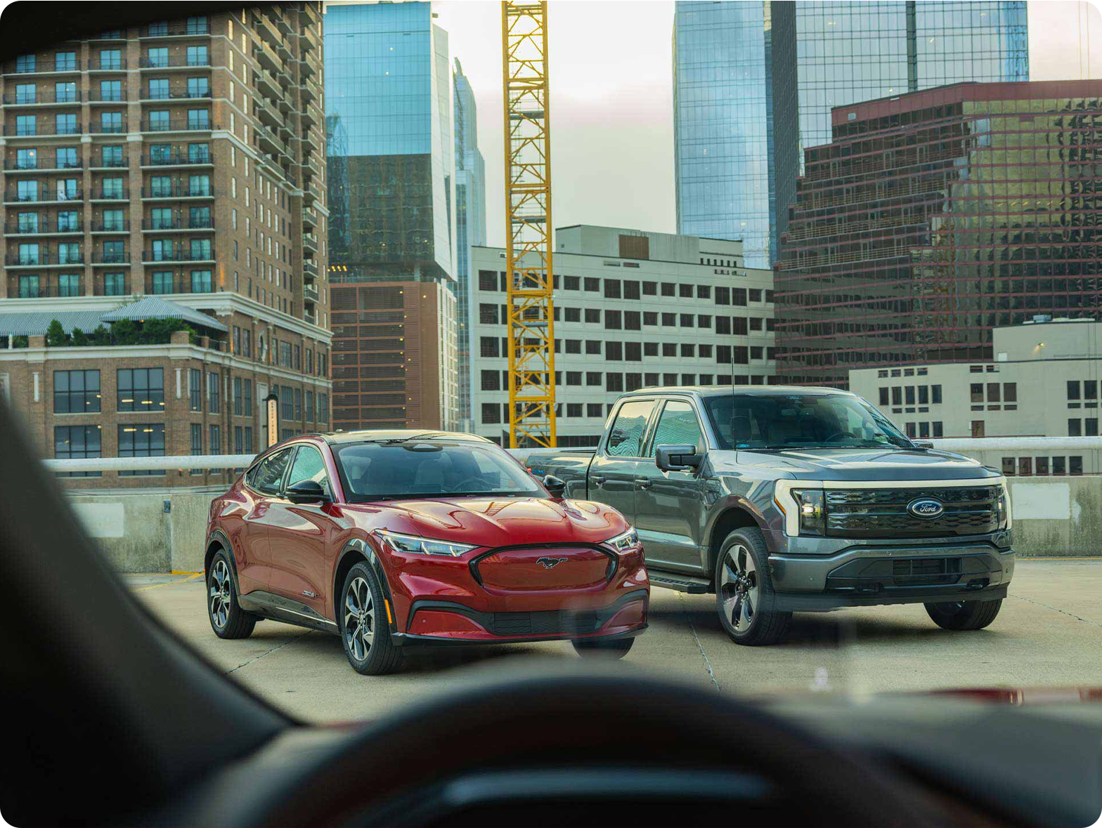 A Mustang Mach-E and F-150 Lightning sitting next to each other on a rooftop.