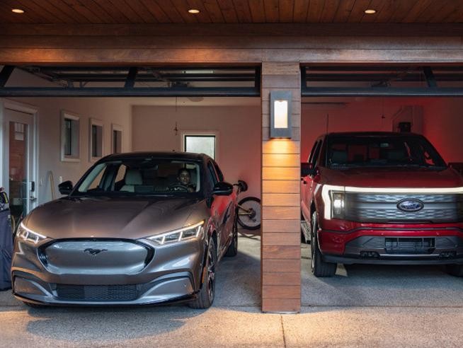 A Mustang Mach-E® and F-150 Lightning® parked side by side in a residential garage