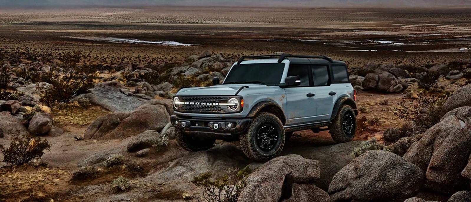 Blue 2021 Ford Bronco parked on a mountain. Blue 2021 Ford Bronco parked on a mountain.