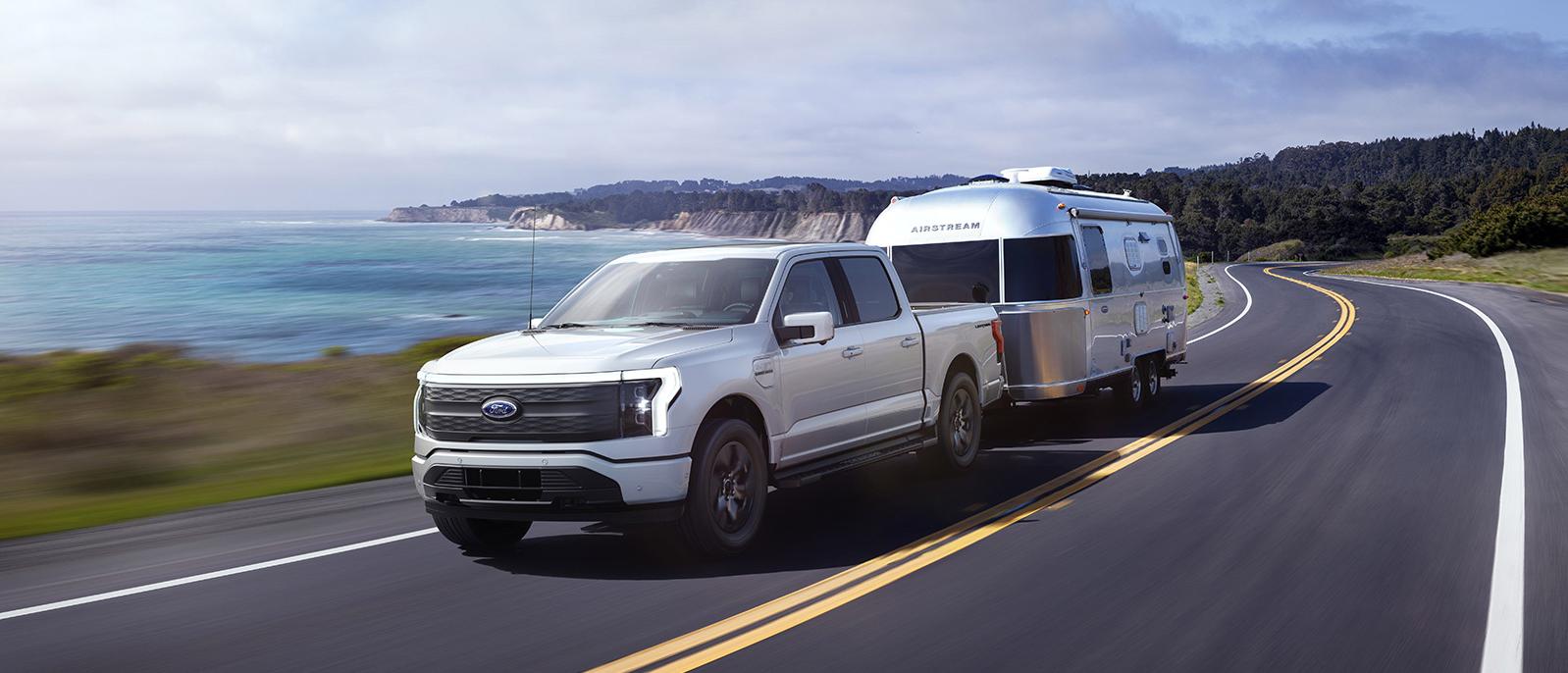 2022 white Ford F-150 Lightening is running on the road. 2022 white Ford F-150 Lightening is running on the road.