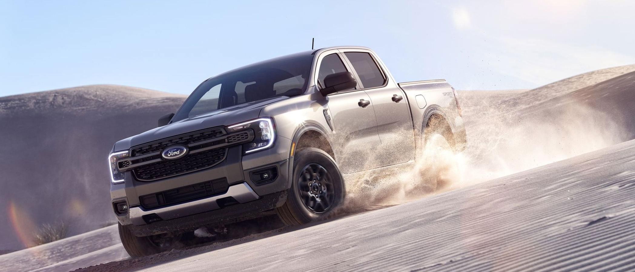 A 2024 Ford Ranger® XLT in Iconic Silver is being driven on a desert dune.