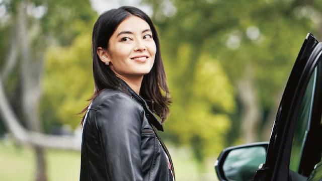 Woman standing next to vehicle Woman standing next to vehicle