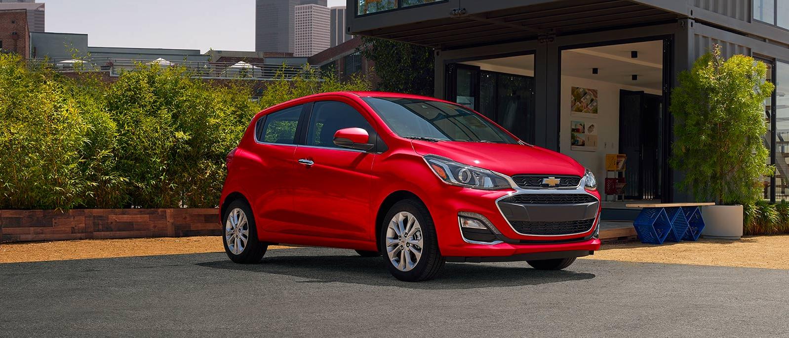 Red Chevrolet Spark parked near house Red Chevrolet Spark parked near house