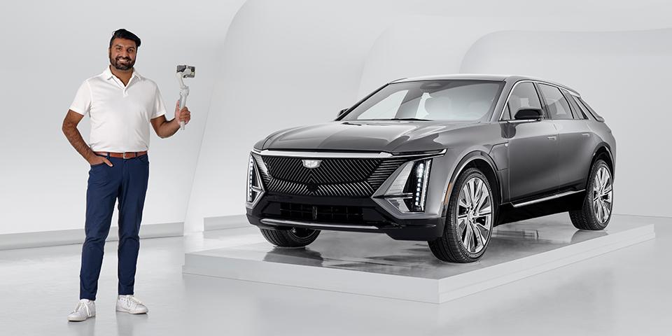 Man standing with steady cam next to a 2023 Cadillac Lyriq in a white room