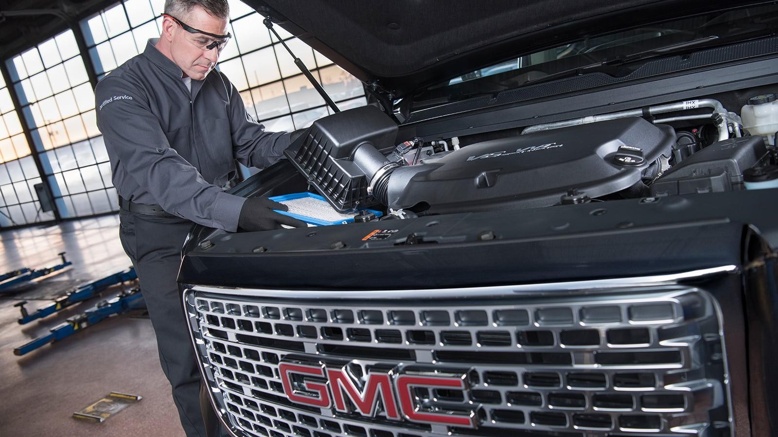 GMC certified service mechanic replacing a vehicle's air filter