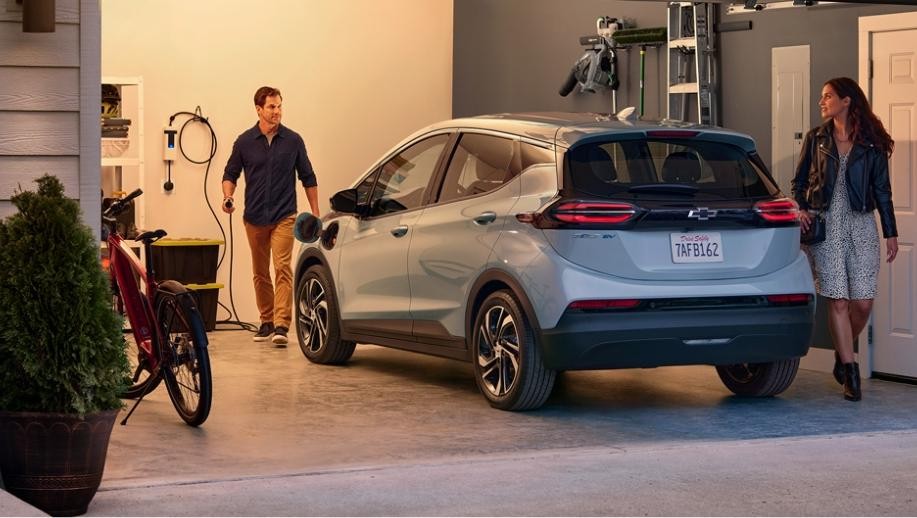 A Couple Standing in Their Garage Near Their Chevrolet Bolt EV