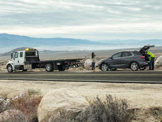 Tow truck and Equinox in desert with worker helping tow car Tow truck and Equinox in desert with worker helping tow car