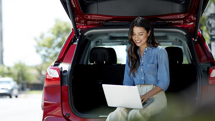 Woman on Chevy Tailgate on Laptop Woman on Chevy Tailgate on Laptop