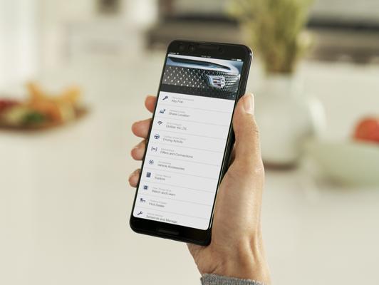 Person holding phone with cadillac onstar app