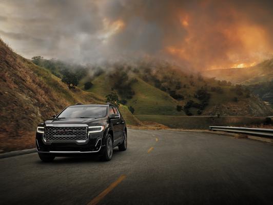 Black GMC driving away from fire in mountains Black GMC driving away from fire in mountains