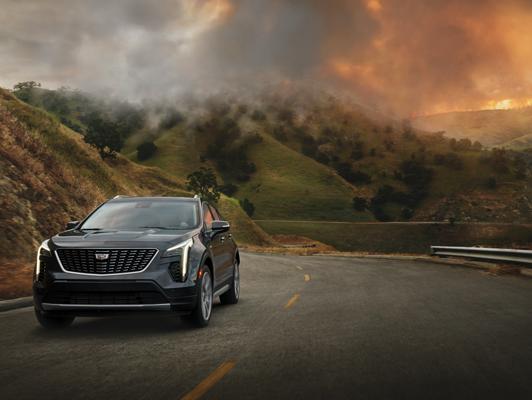 Cadillac driving away from fires in mountains