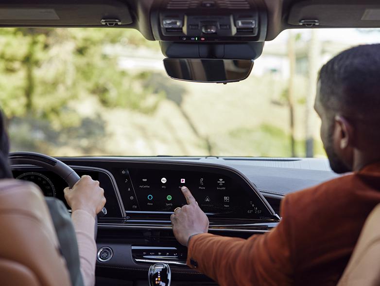 Man touching app screen on cadillac