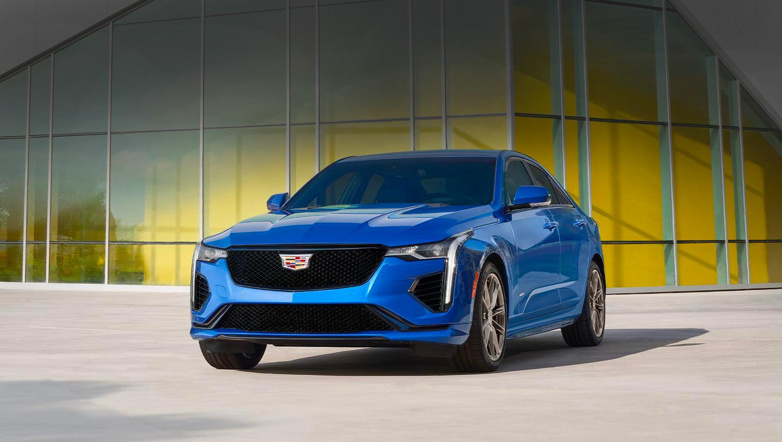 A Blue 2023 Cadillac CT4-V parked near a glass building