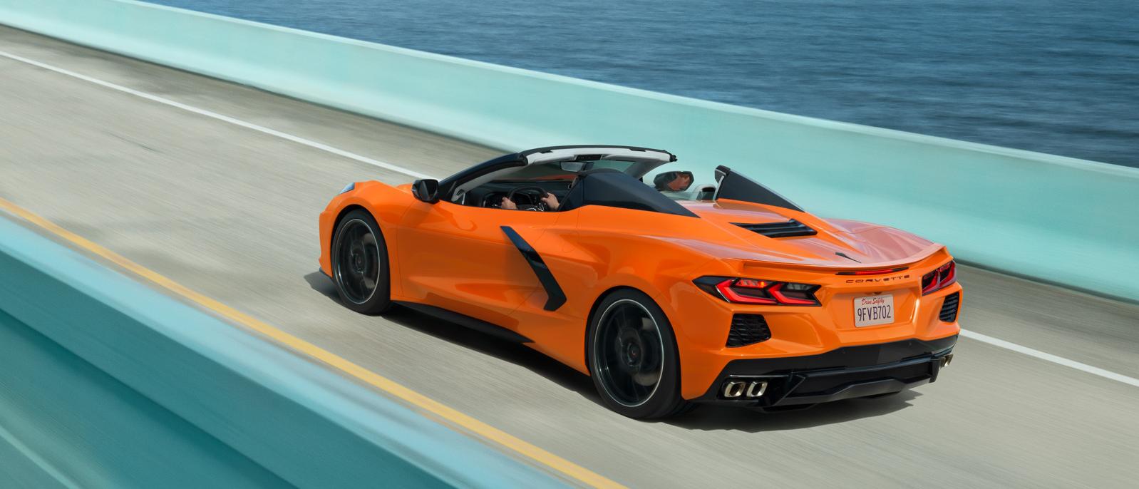 An orange Chevy Corvette cruising across a turquoise bridge. An orange Chevy Corvette cruising across a turquoise bridge.