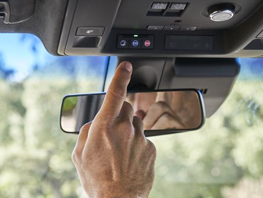 Man pushing onstar button on cadillac