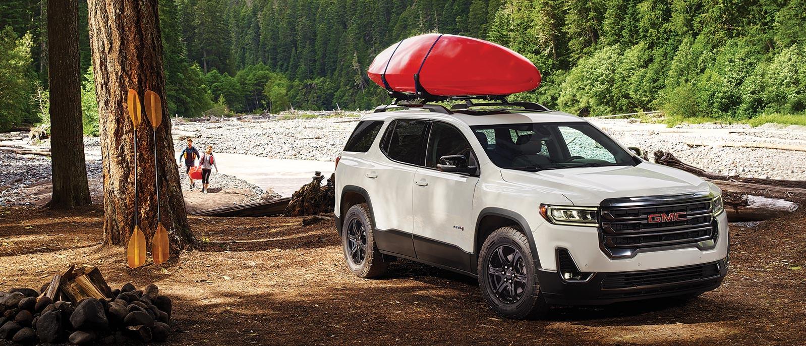 2020 GMC Acadia parked in a forest with river in the background. 2020 GMC Acadia parked in a forest with river in the background.