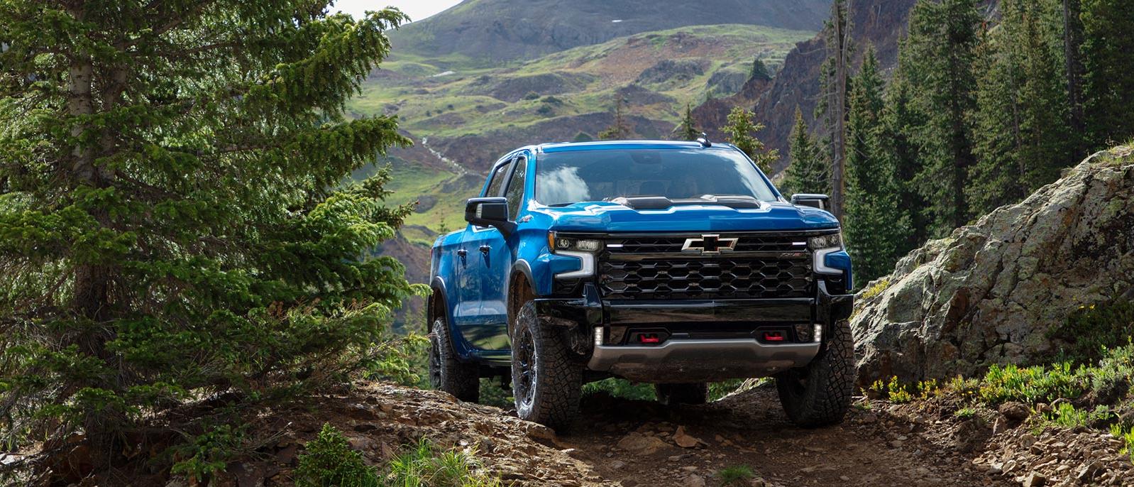 A blue Chevy Silverado 1500 driving through a mountain path. A blue Chevy Silverado 1500 driving through a mountain path.