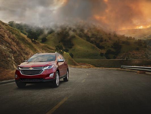Red Equinox driving away from fire in mountains Red Equinox driving away from fire in mountains