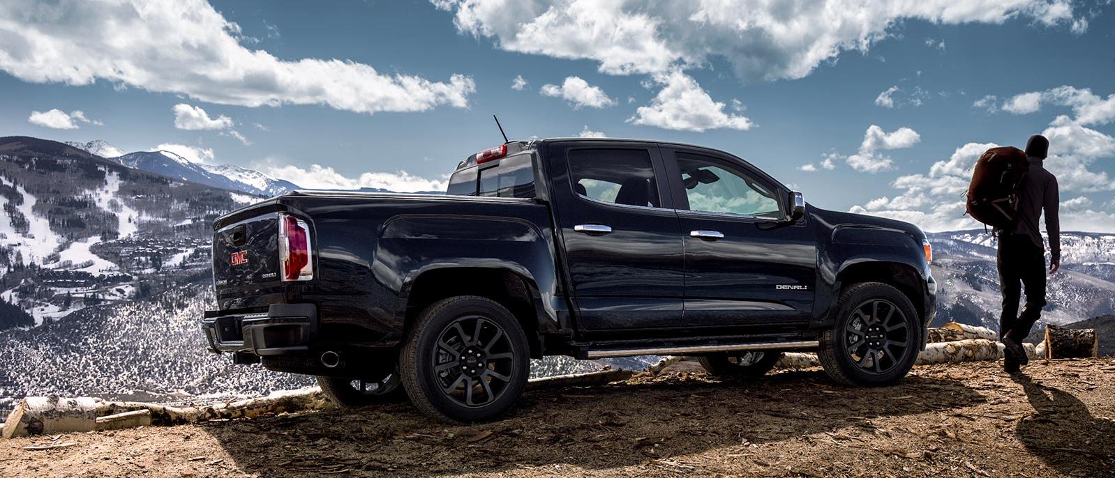 A 2020 GMC Canyon parked at a mountain trailhead A 2020 GMC Canyon parked at a mountain trailhead