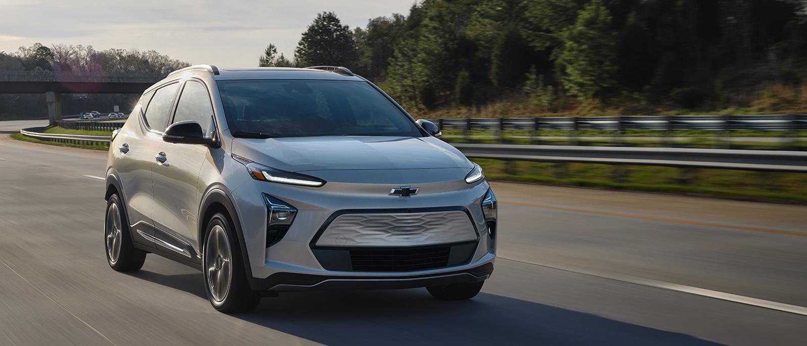 A light blue Chevy Bolt EUV driving on a countryside highway. A light blue Chevy Bolt EUV driving on a countryside highway.