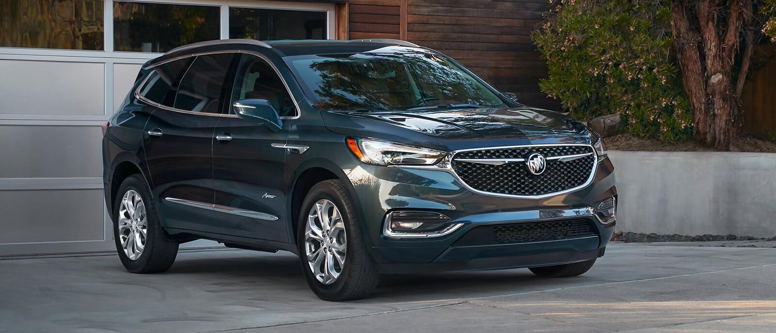 A 2021 Buick Enclave Avenir parked in front of a house.